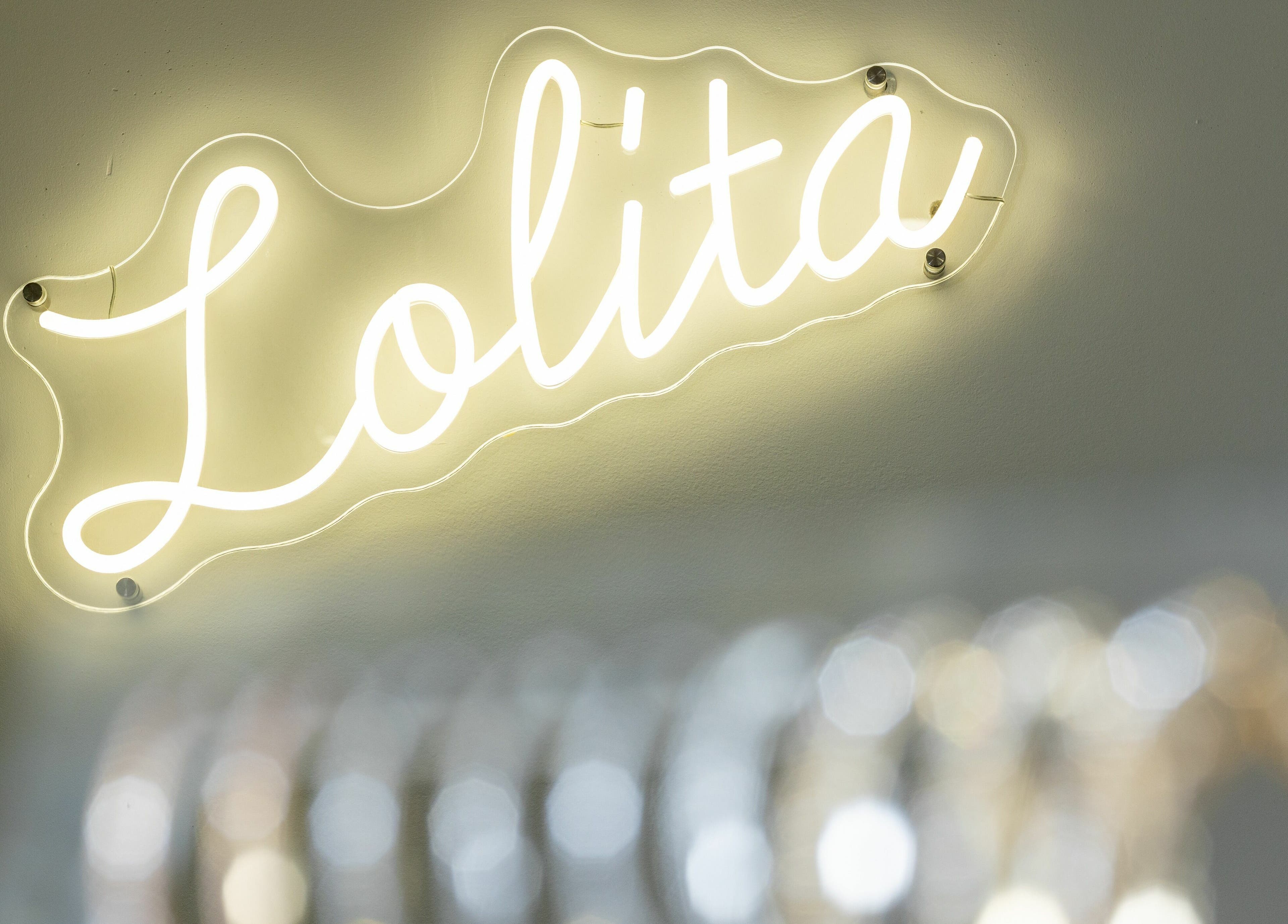 Lolita Beaute neon sign in Montréal, Québec, CA, glowing warmly on the wall.