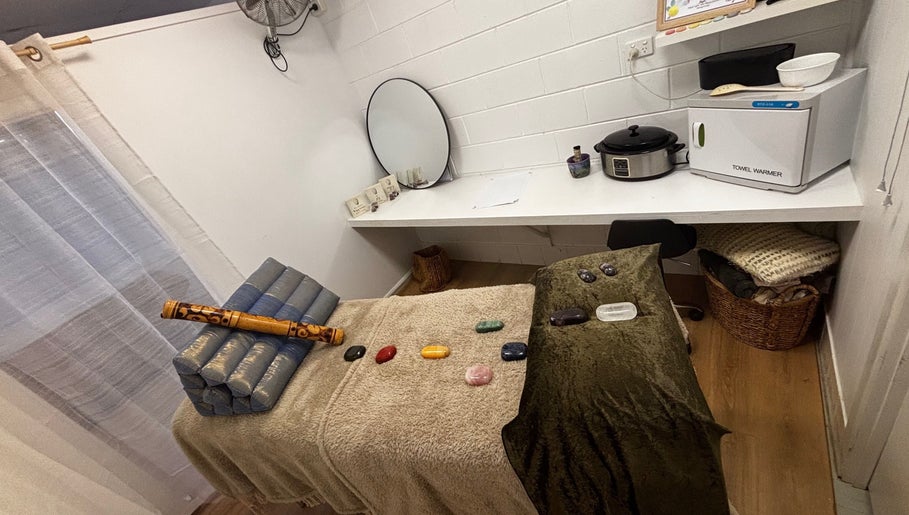 Therapy room at Sol Nourishments, Pimlico, Queensland, AU with massage table and healing stones.