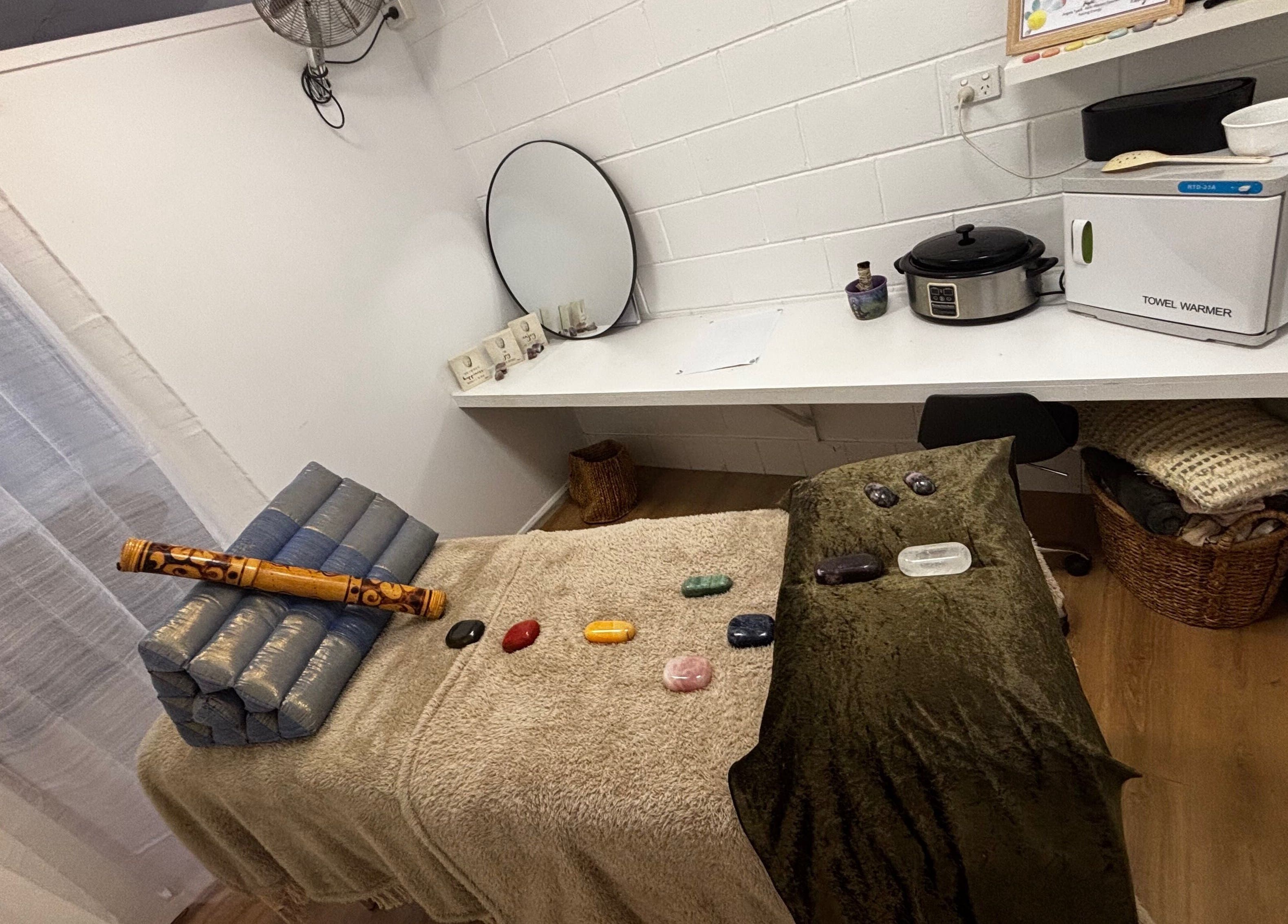 Therapy room at Sol Nourishments, Pimlico, Queensland, AU with massage table and healing stones.