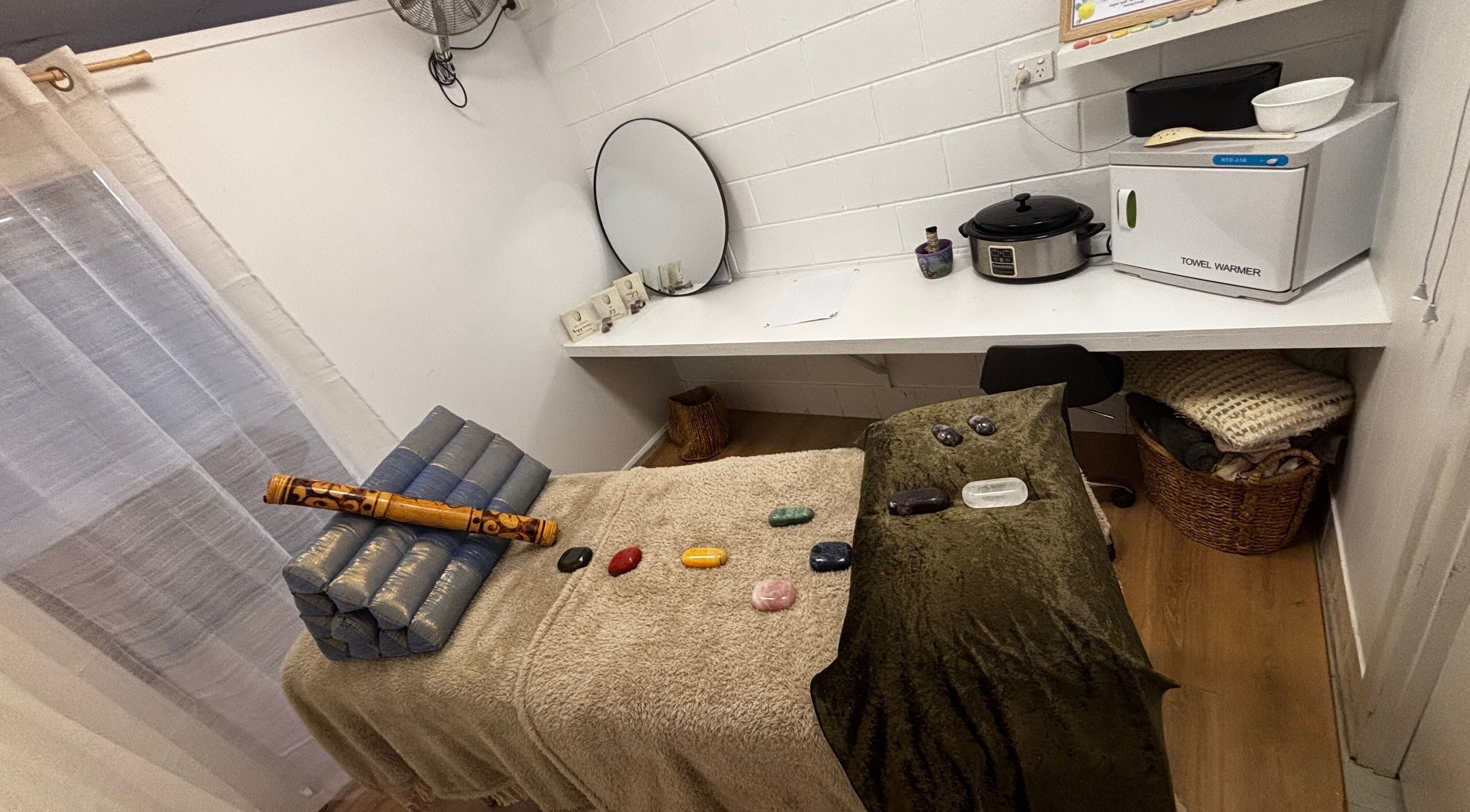 Therapy room at Sol Nourishments, Pimlico, Queensland, AU with massage table and healing stones.