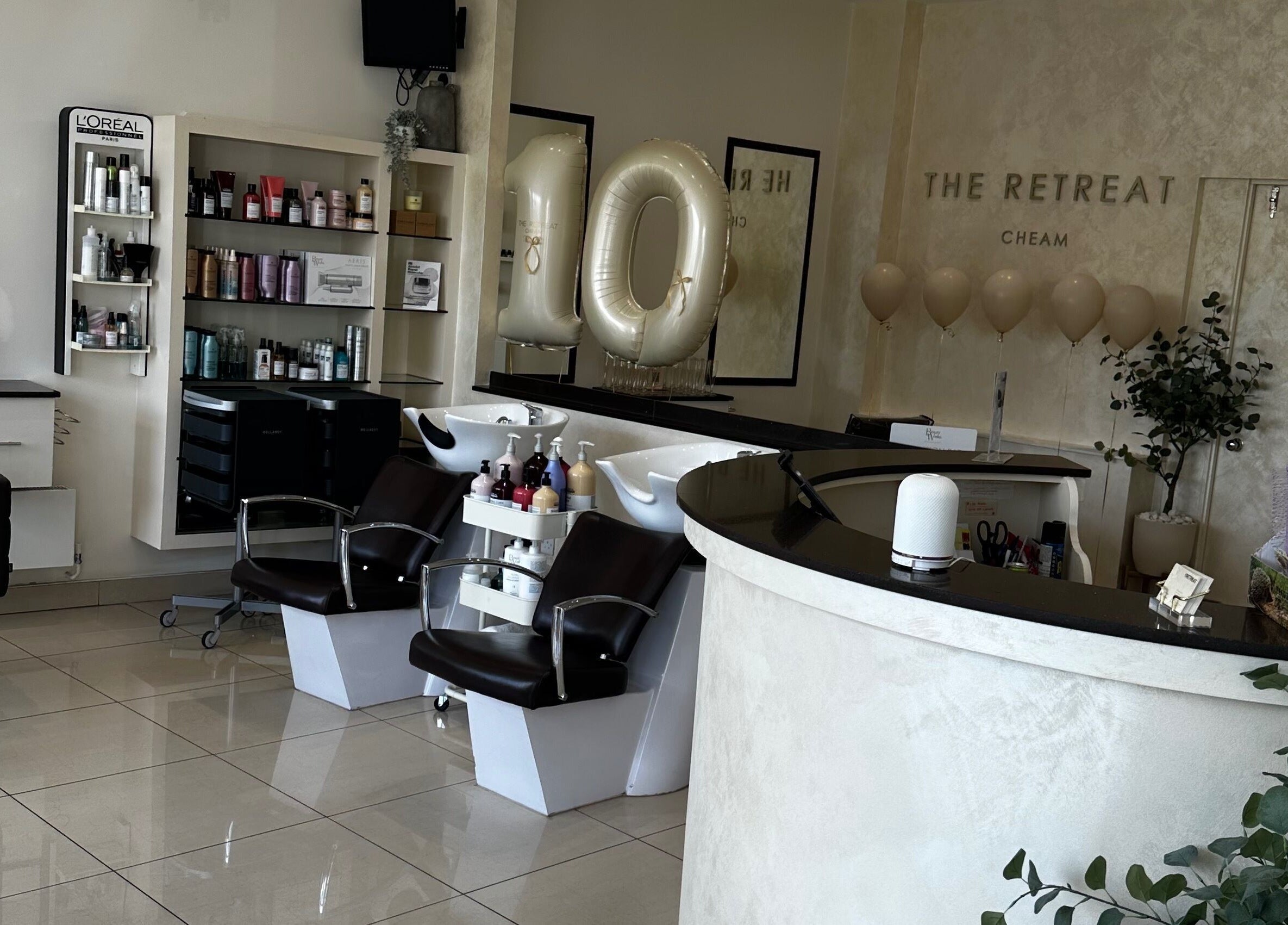 Chic salon interior at The Retreat, Sutton, England, GB showcasing modern chairs and stylish product displays.