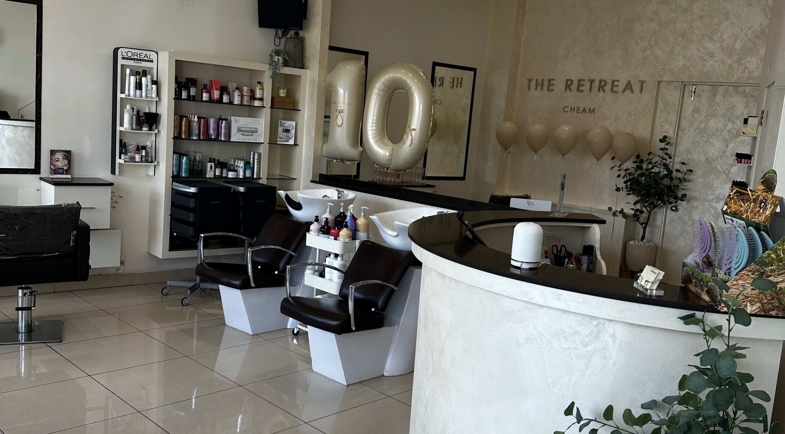 Chic salon interior at The Retreat, Sutton, England, GB showcasing modern chairs and stylish product displays.