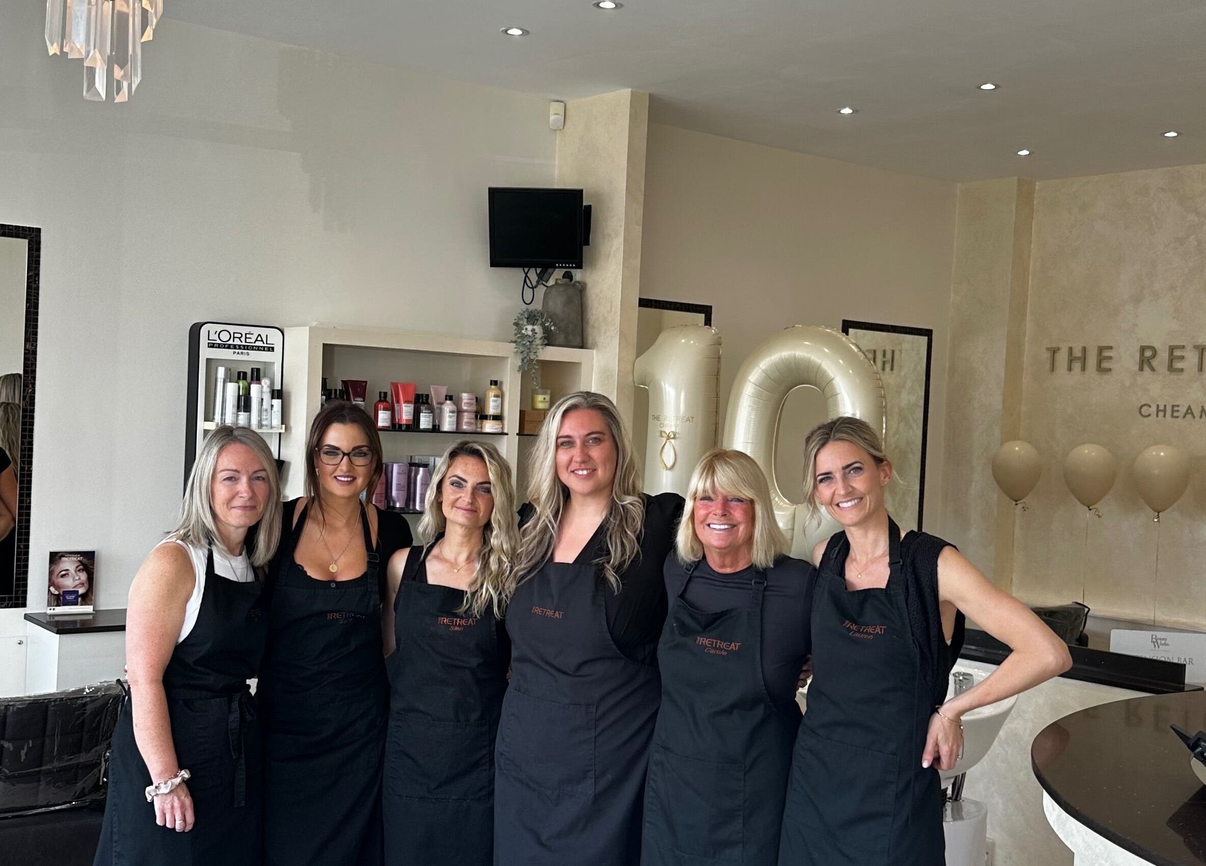 Happy team at The Retreat, Sutton, England, GB, celebrating in a chic beauty and wellness space.