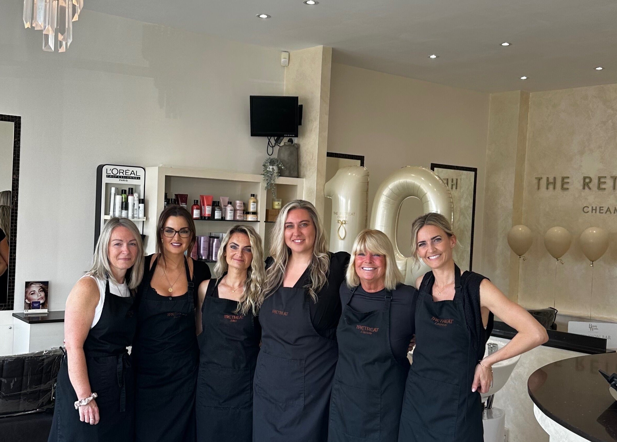 Happy team at The Retreat, Sutton, England, GB, celebrating in a chic beauty and wellness space.