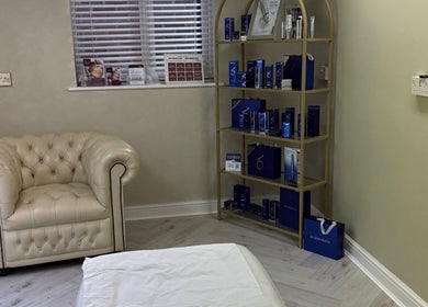 Cozy aesthetic room at Karen Brereton Aesthetics, Loughborough, England, GB with an elegant chair and product display.