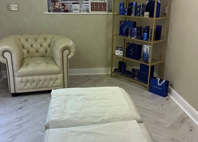 Elegant treatment room at Karen Brereton Aesthetics, Loughborough, England, GB with plush chair and skincare display.