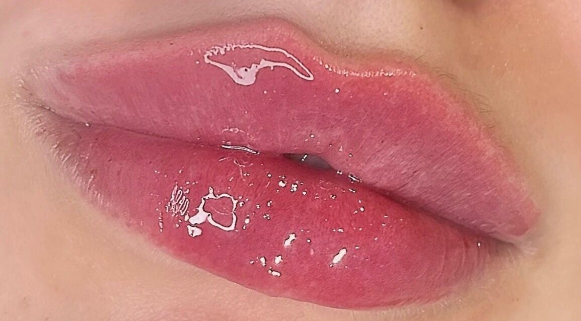 Close-up of glossy pink lips, showcasing beauty treatment at AE Clinics (Sudbury), Sudbury, England, GB.