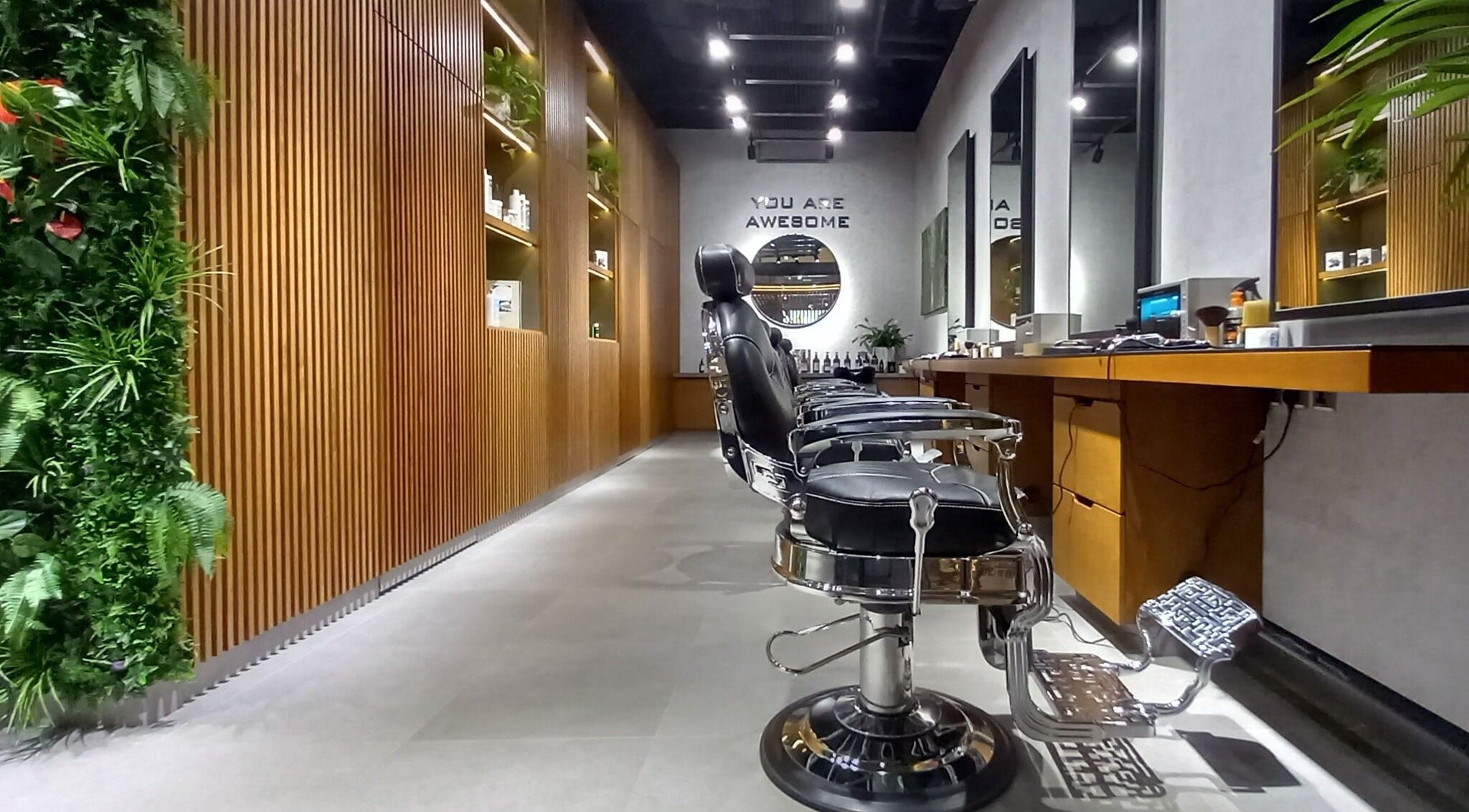 Elegant interior of Grow Organic Gents Salon in Dubai, AE, featuring sleek barber chairs and vertical garden.
