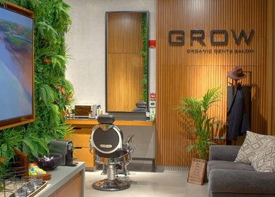 Interior of Grow Organic Gents Salon in Dubai, AE with stylish chair, lush plants, and chic decor.