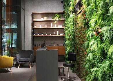 Chic interior at Grow Organic Gents Salon, Dubai, AE showcasing lush greenery and modern seating.