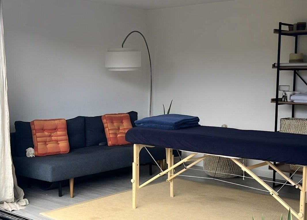 A serene massage room at Alpha Massage - Chobham Clinic, featuring a treatment table and cozy decor, Chobham, England, GB.