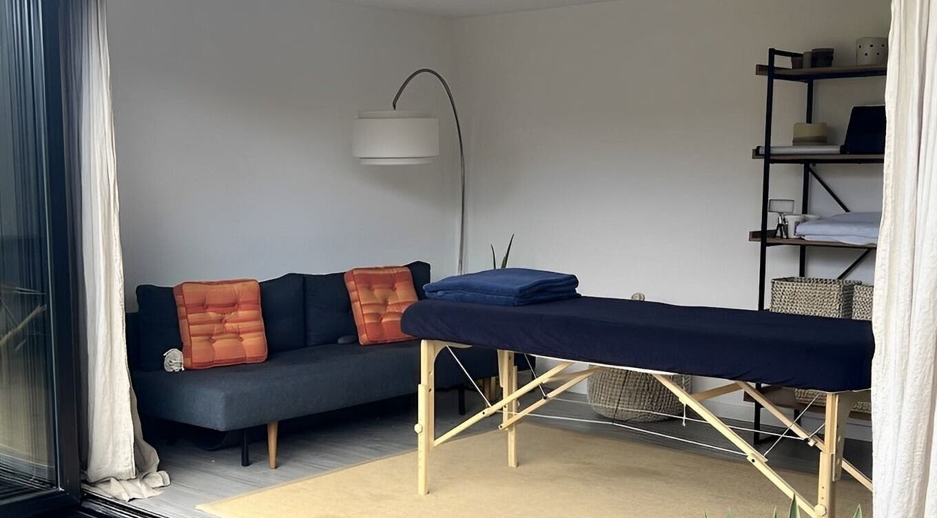 A serene massage room at Alpha Massage - Chobham Clinic, featuring a treatment table and cozy decor, Chobham, England, GB.
