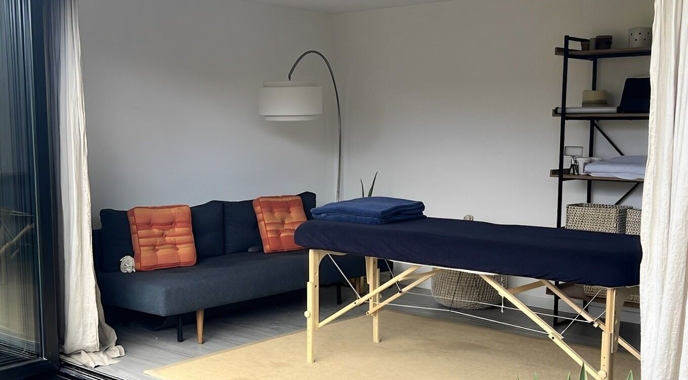 A serene massage room at Alpha Massage - Chobham Clinic, featuring a treatment table and cozy decor, Chobham, England, GB.