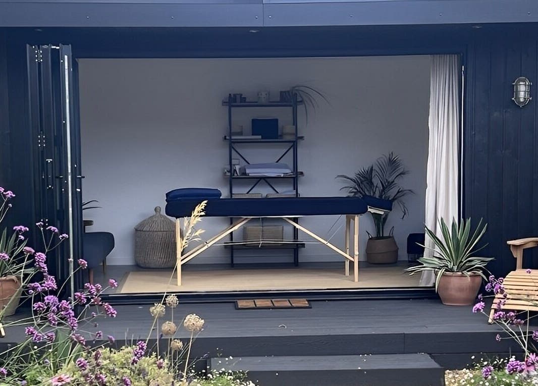 Tranquil therapy room at Alpha Massage - Chobham Clinic, Chobham, England, surrounded by lush greenery.