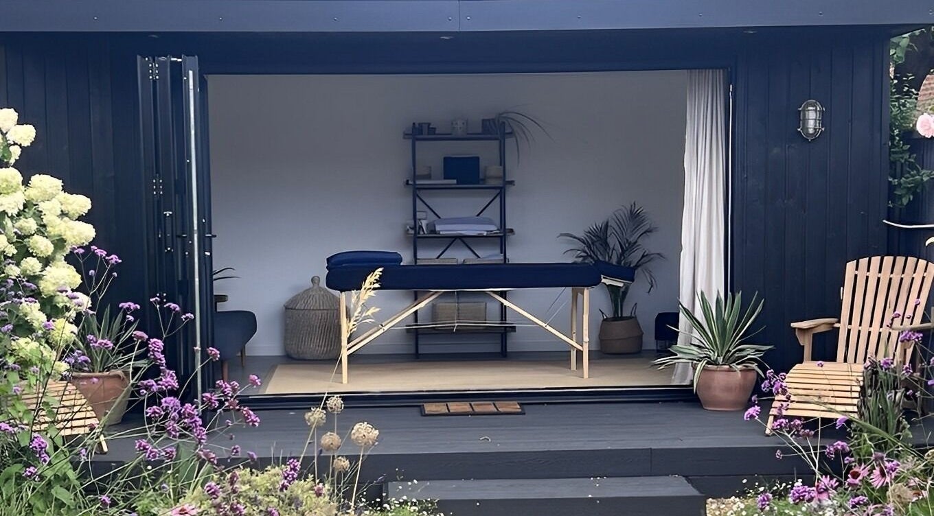 Tranquil therapy room at Alpha Massage - Chobham Clinic, Chobham, England, surrounded by lush greenery.