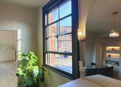 A sunlit room at Shaw Beauty, Sandbach, England, GB featuring elegant furnishings and large windows.