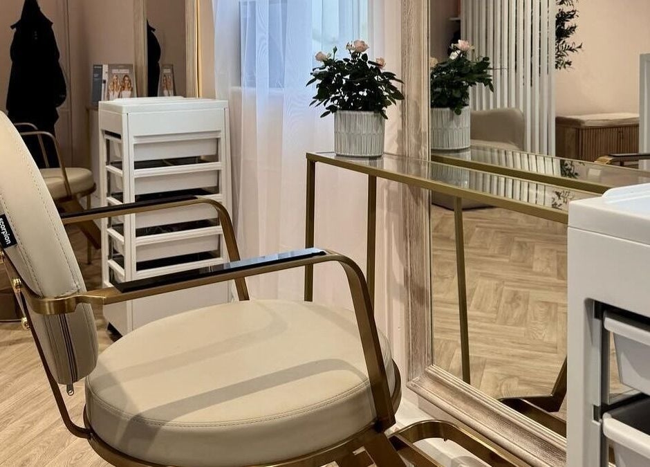 Chic beauty salon interior at By Becky Studios, Wells, England, GB. Features plush chairs and a stylish mirror.