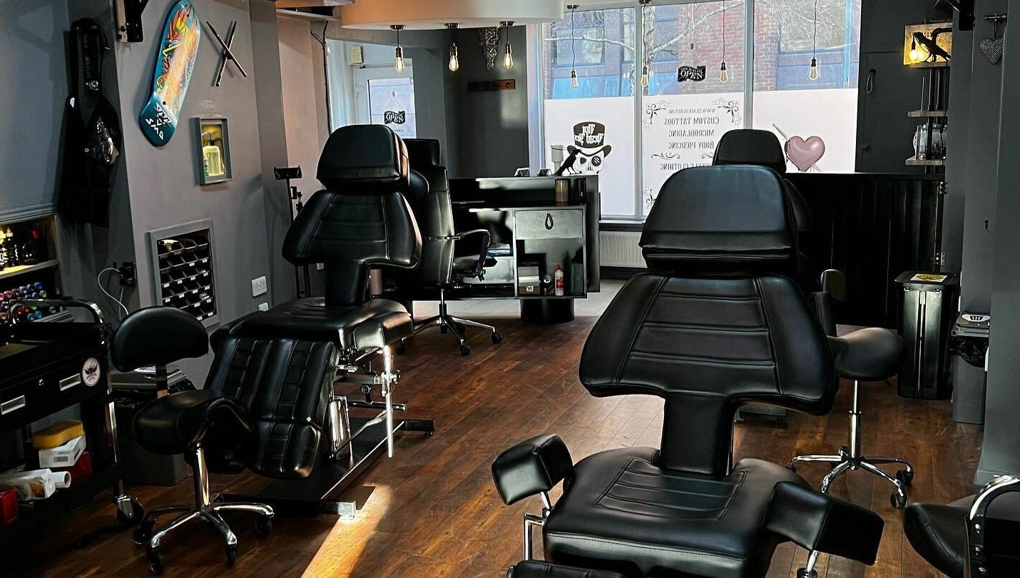 Modern tattoo studio interior at Black Heart Ink, featuring sleek black chairs in Swindon, England, GB.