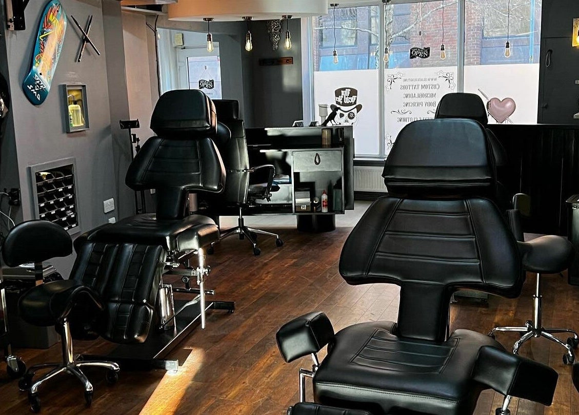 Modern tattoo studio interior at Black Heart Ink, featuring sleek black chairs in Swindon, England, GB.