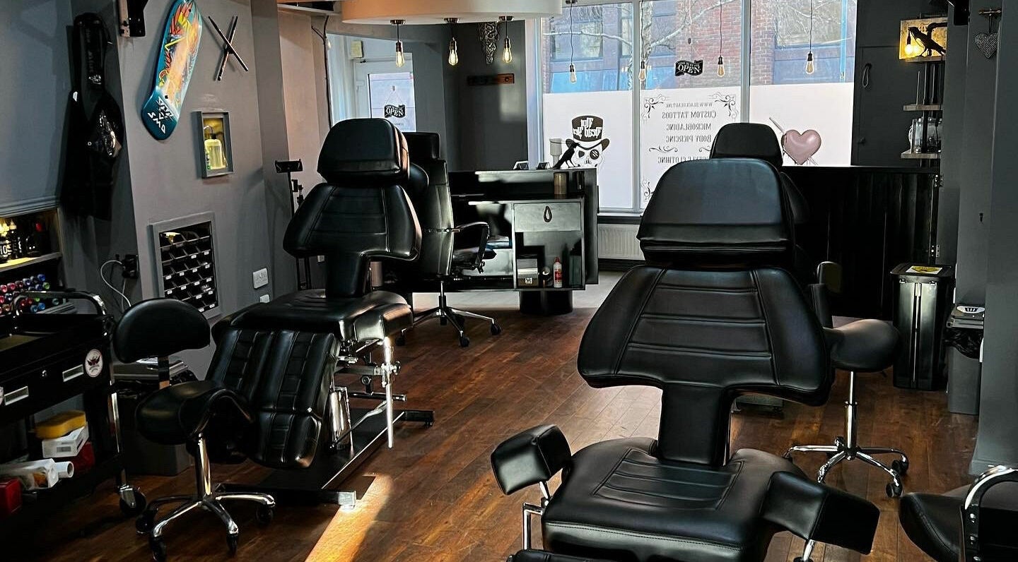 Modern tattoo studio interior at Black Heart Ink, featuring sleek black chairs in Swindon, England, GB.