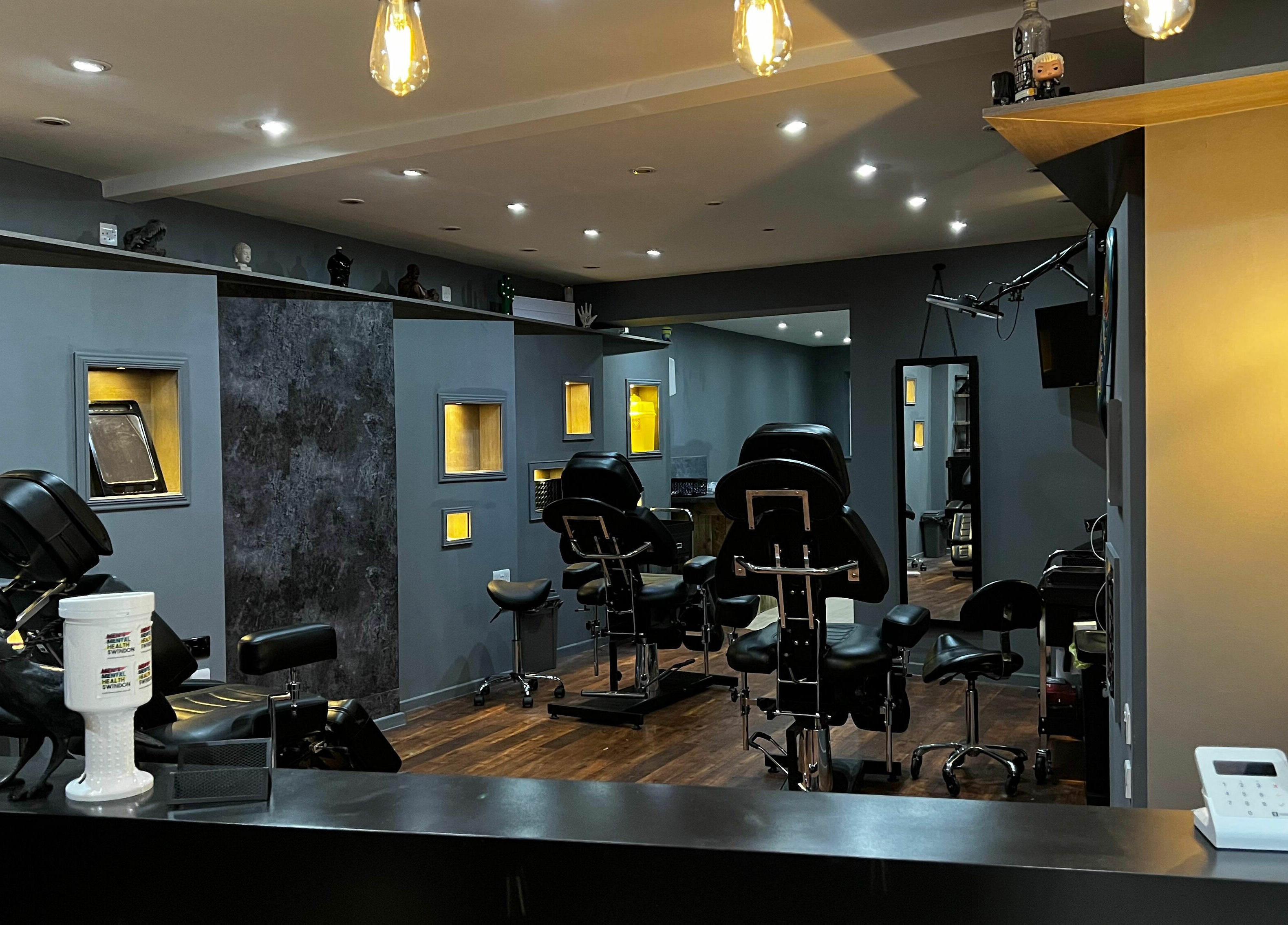 Interior of Black Heart Ink, a stylish tattoo studio in Swindon, England, GB with modern decor and lighting.