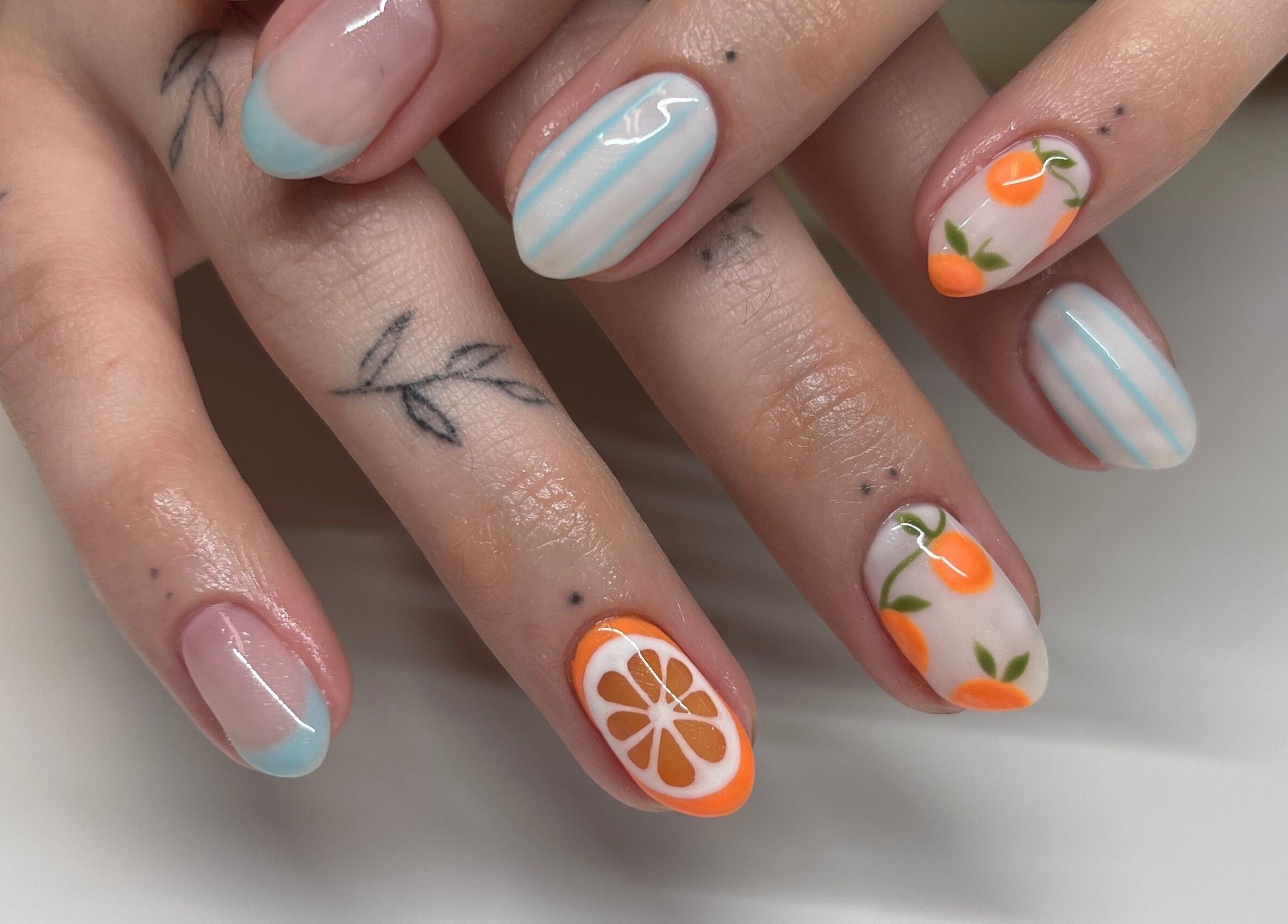 Vibrant citrus-themed nail art by Nails By Elli in Bryan, Ohio, US, featuring delicate blue stripes.