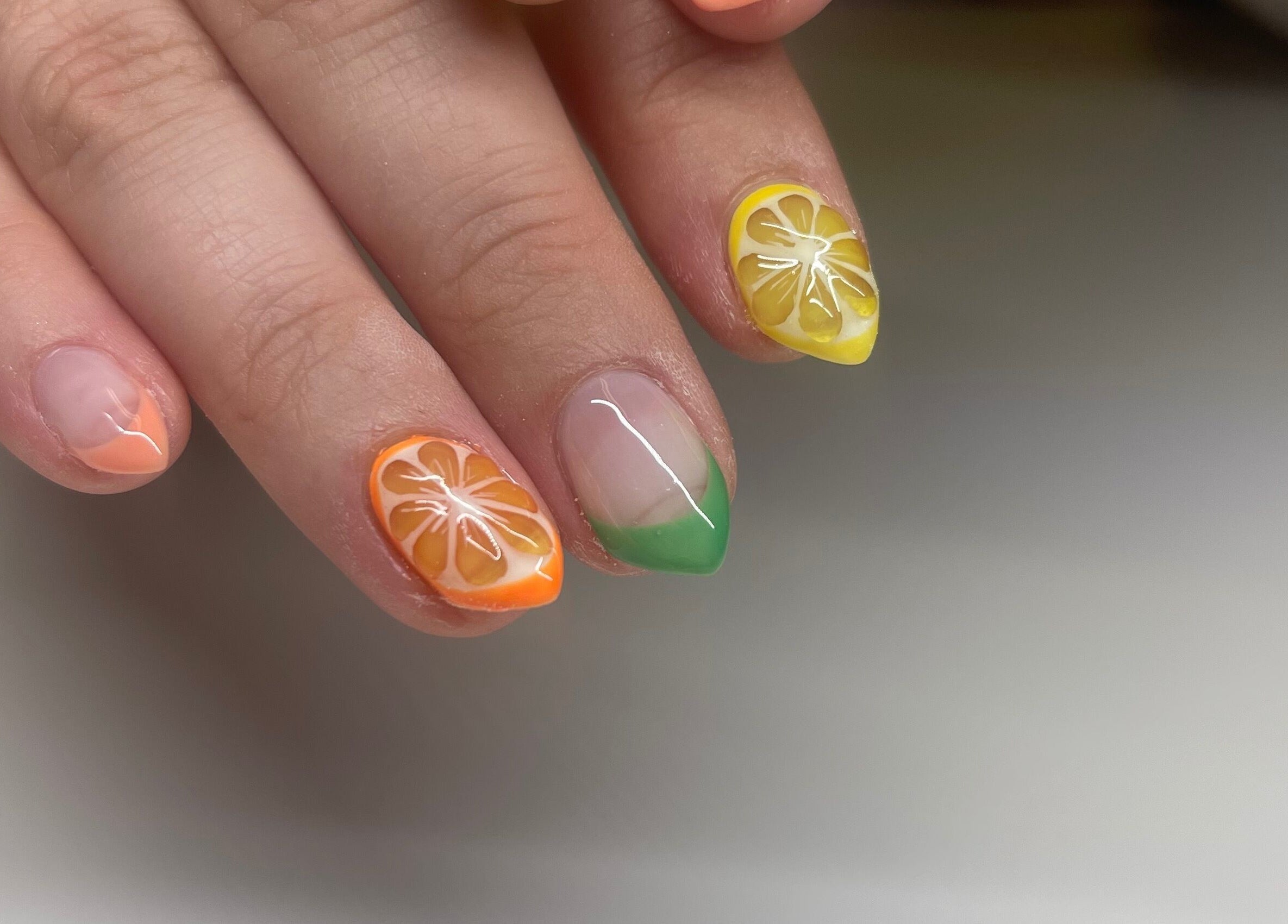 Vibrant citrus-themed nail art at Nails By Elli, Bryan, Ohio, US, showcasing detailed orange and lemon designs.