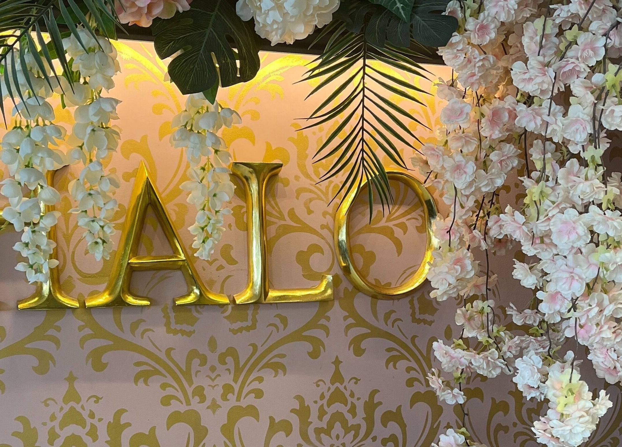 Floral decor at Halo, Newcastle-under-Lyme, England, GB, with gold lettering and lush green accents.
