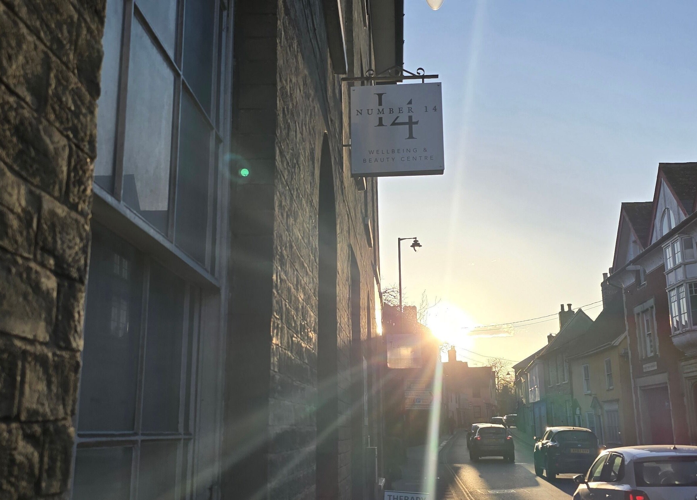 Charming street view near The Waxing Witch Suffolk in Sudbury, England, GB, with sunset lighting and quaint buildings.