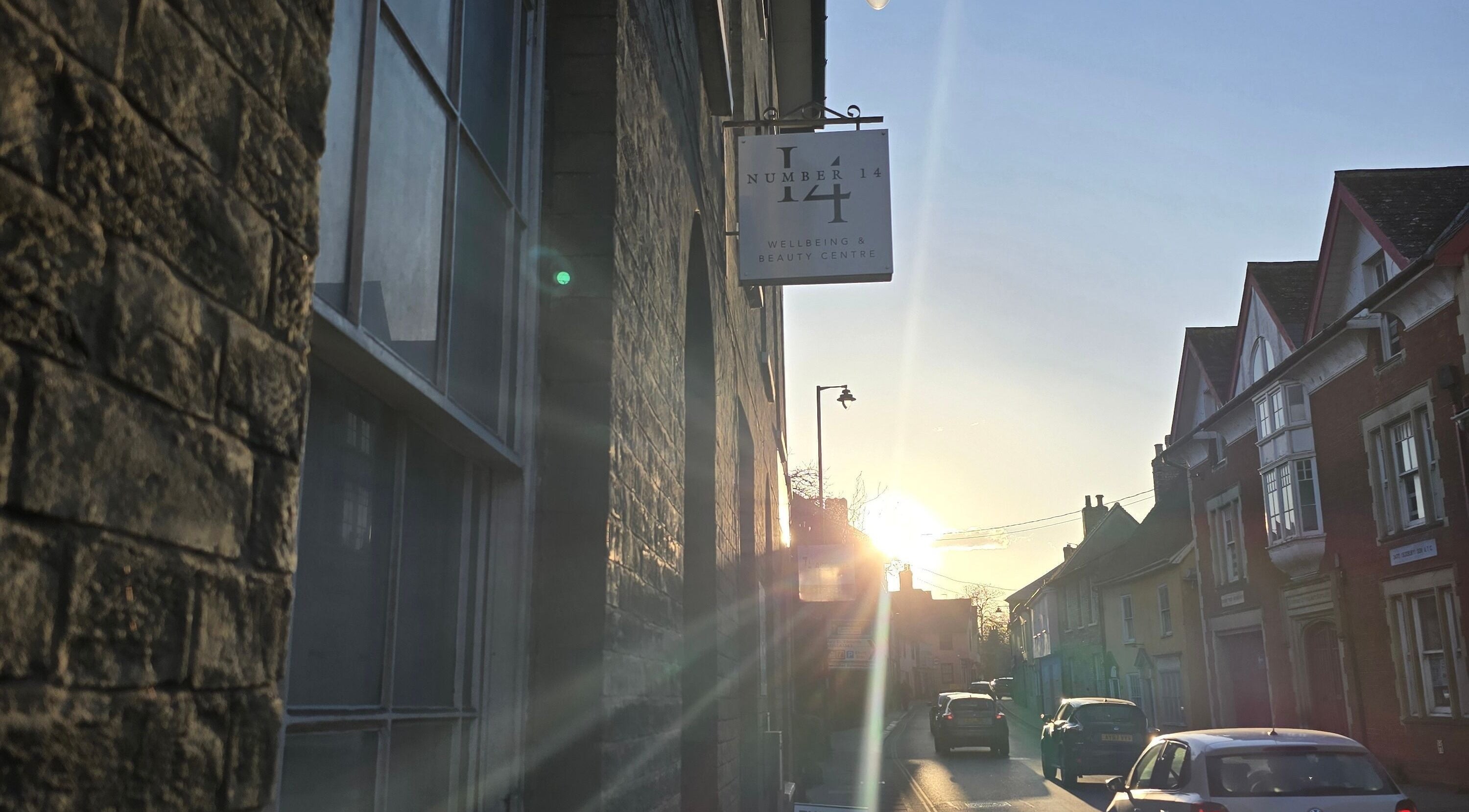 Charming street view near The Waxing Witch Suffolk in Sudbury, England, GB, with sunset lighting and quaint buildings.