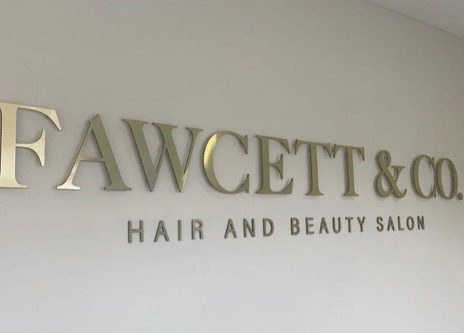 Fawcett & Co. Hair and Beauty Salon signage in Leeds, England, GB on display wall.