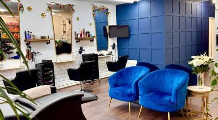 Modern interior of Hair by Codi salon in Northampton, England, GB with blue chairs and elegant mirrors.