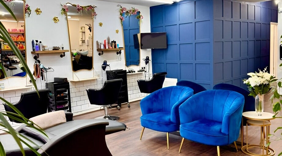 Stylish interior of Hair by Codi, Northampton, England with blue chairs and elegant decor.