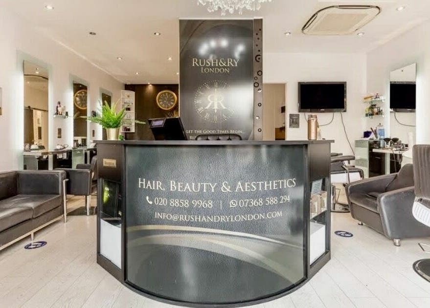 Reception area of Rush&RyNorth Greenwich salon in London, England, GB, featuring modern decor and stylish seating.