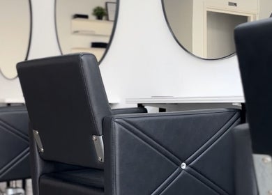 Modern salon chairs and mirrors at Hun Salon, Alton, England, GB, showcasing sleek, stylish design.