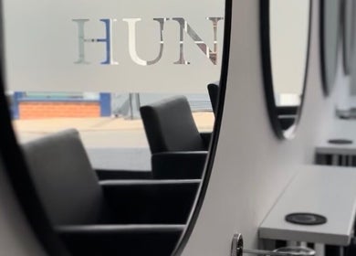Stylish salon mirrors at Hun Salon, Alton, England, GB reflecting modern salon chairs and minimalist design.