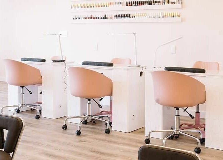 Elegant nail bar at Nails & Co. Windsor, Windsor, Ontario, CA with pink chairs and polished stations.