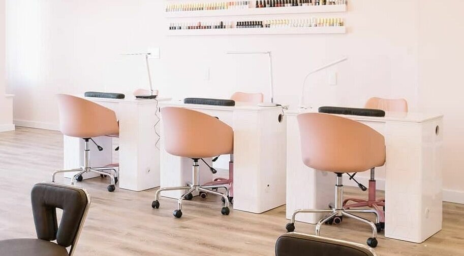 Elegant nail bar at Nails & Co. Windsor, Windsor, Ontario, CA with pink chairs and polished stations.