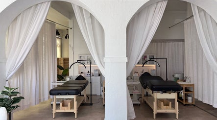 Relaxing treatment rooms at Aura Beauty LLC in Kenosha, Wisconsin, US with white curtains and massage tables.