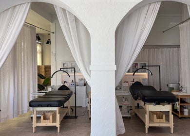 Calm treatment rooms at Aura Beauty LLC, Kenosha, Wisconsin, US with elegant white drapes and massage tables.
