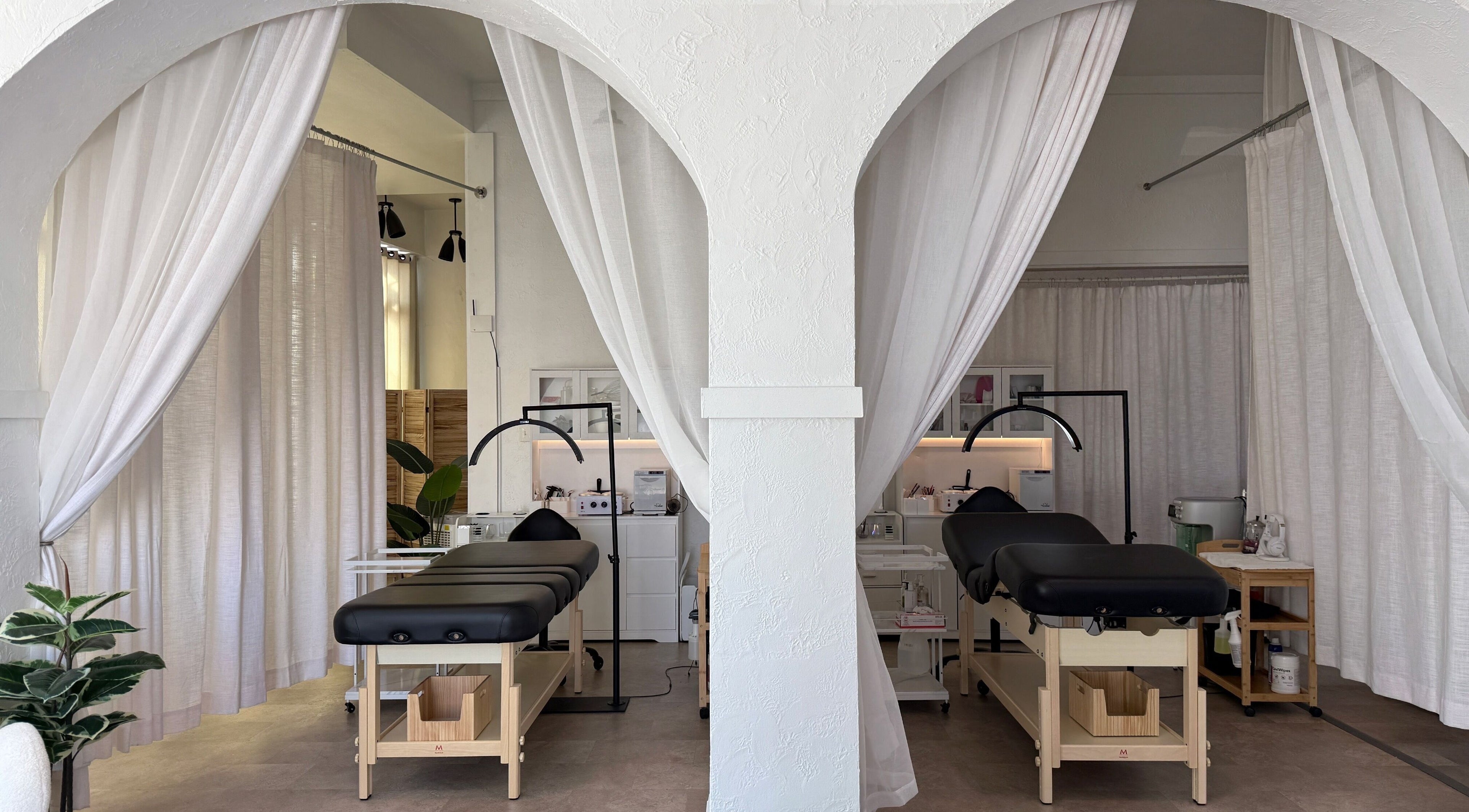 Calm treatment rooms at Aura Beauty LLC, Kenosha, Wisconsin, US with elegant white drapes and massage tables.