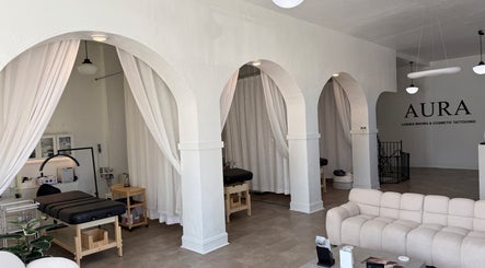 Elegant interior of Aura Beauty LLC in Kenosha, Wisconsin, US, featuring treatment stations and a cozy seating area.