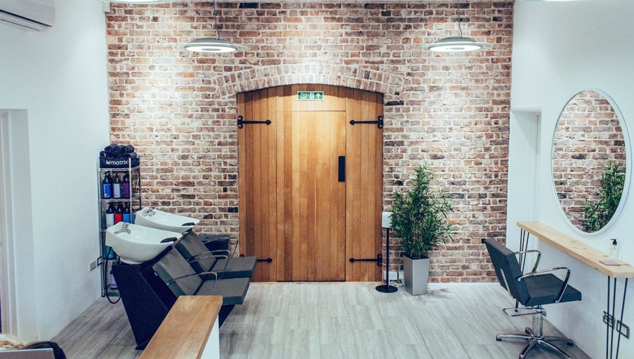 Chic interior of Alice Ellen Hairdressing, Portslade, England, GB with modern wash stations and styling chairs.