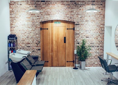 Chic interior of Alice Ellen Hairdressing, Portslade, England, GB with modern wash stations and styling chairs.