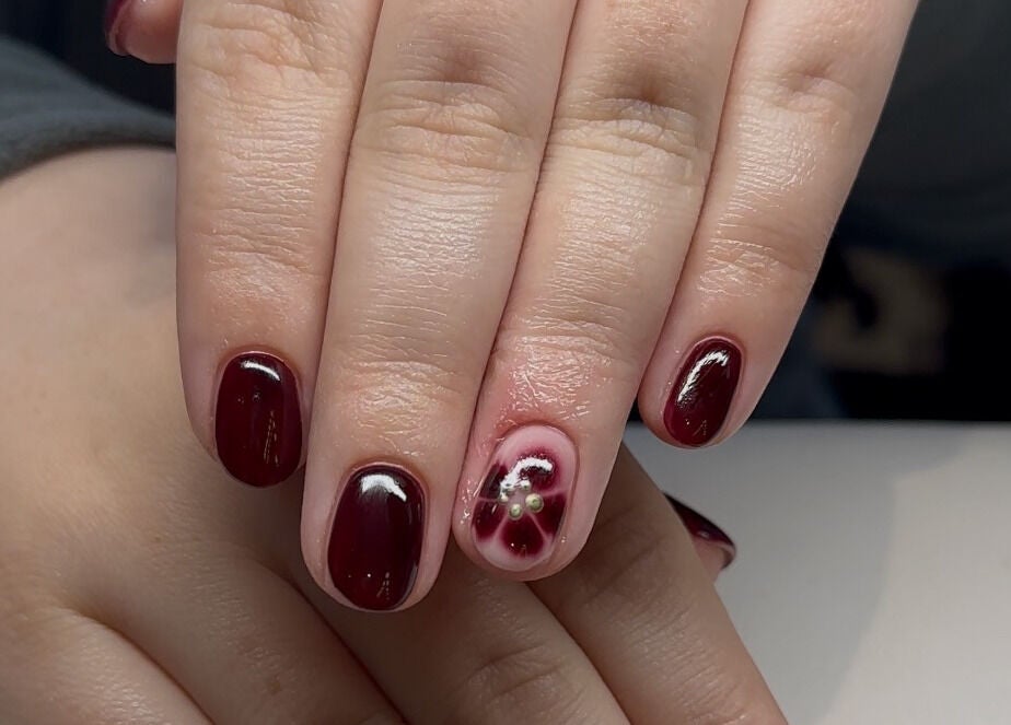 Elegant cranberry manicure with floral accent at The Mani Lounge Cheshire, Congleton, England, GB.
