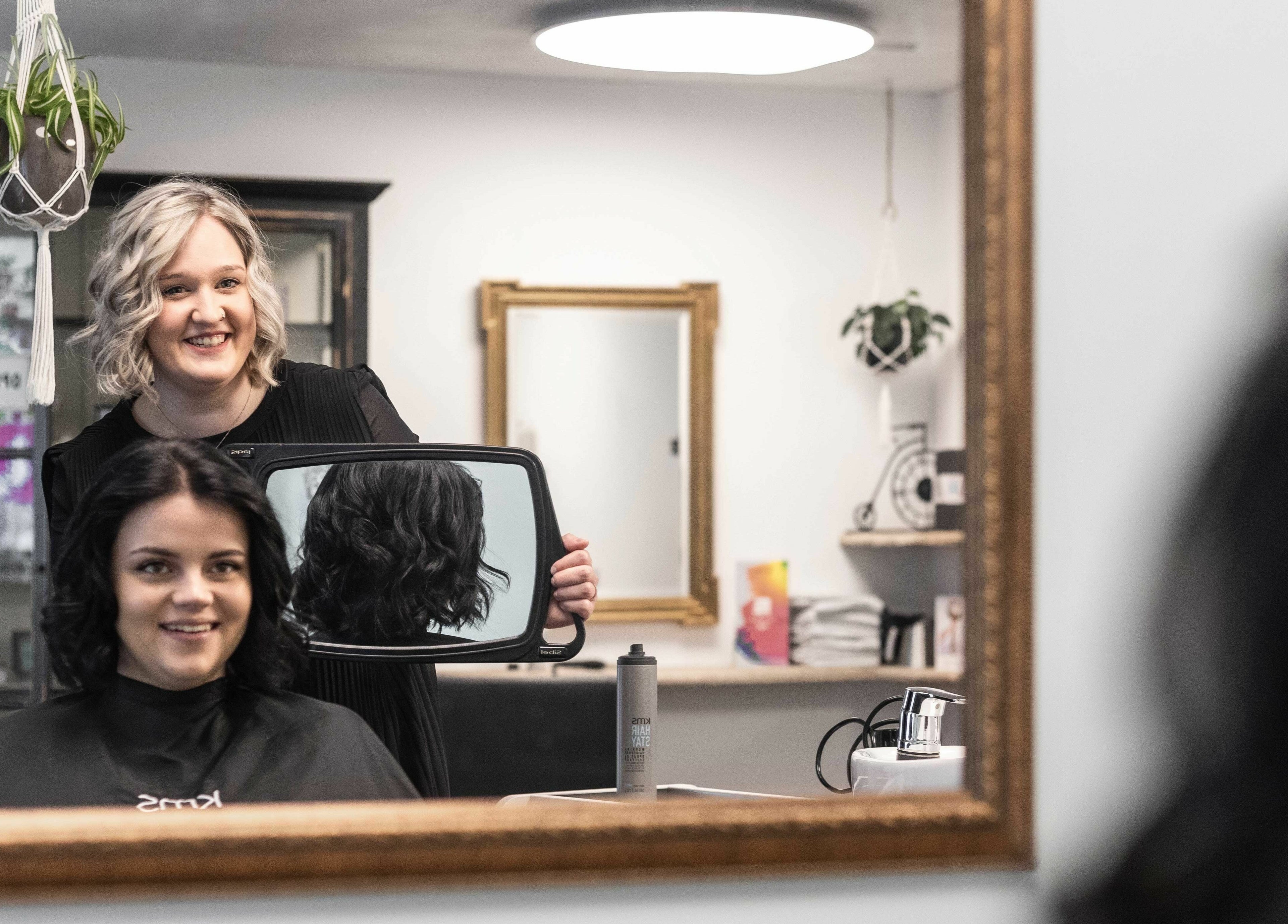 Friseurin und Kundin bei Scherenklang, St. Gallen, Schweiz, CH. Spiegelbild einer neuen Frisur.