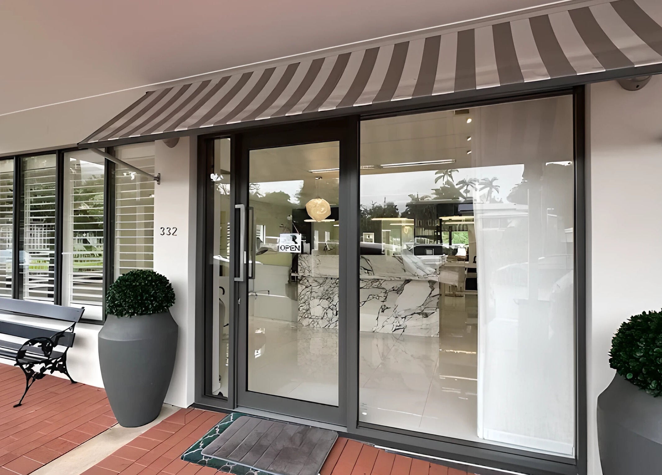 Entrance of The Edge Hill Hairdressers, Edge Hill, Queensland, AU with elegant decor and glass doors.