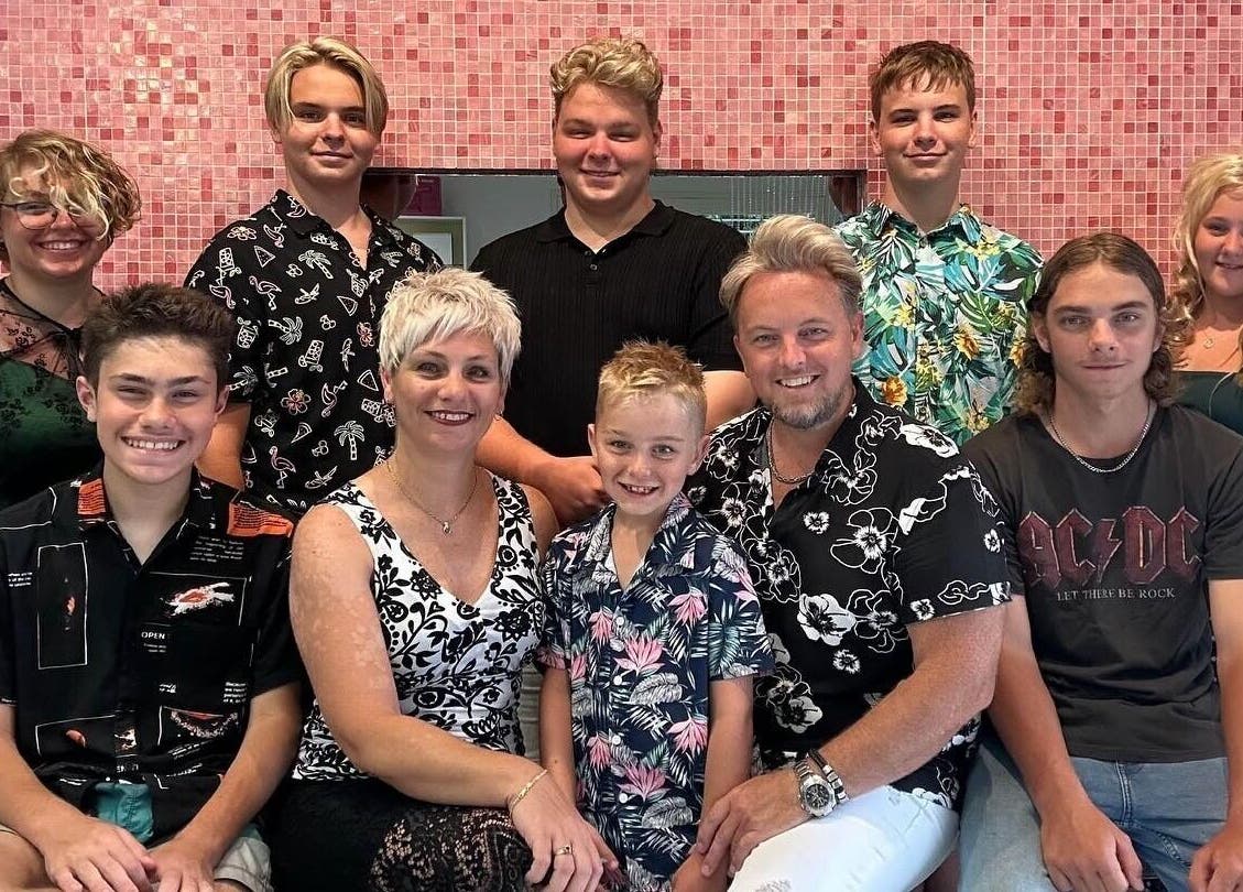 Guests pose at The Edge Hill Hairdressers in Edge Hill, Queensland, AU, against a chic pink backdrop.