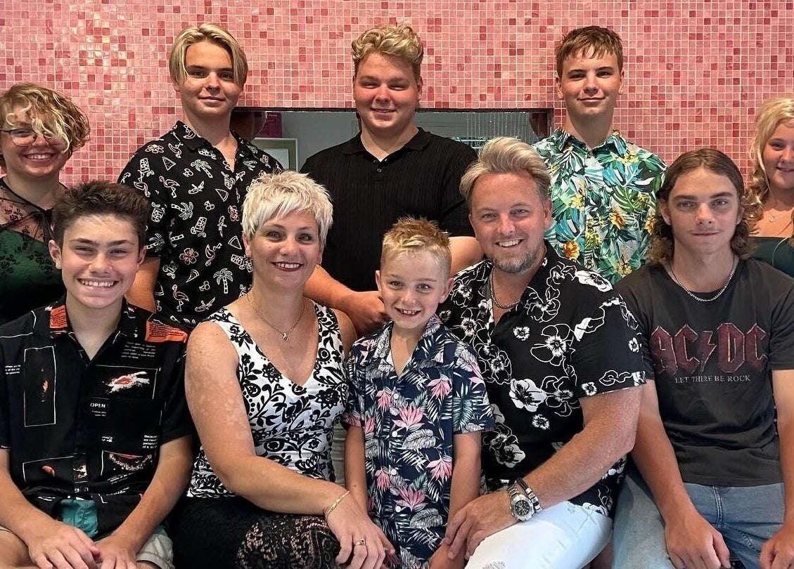 Guests pose at The Edge Hill Hairdressers in Edge Hill, Queensland, AU, against a chic pink backdrop.