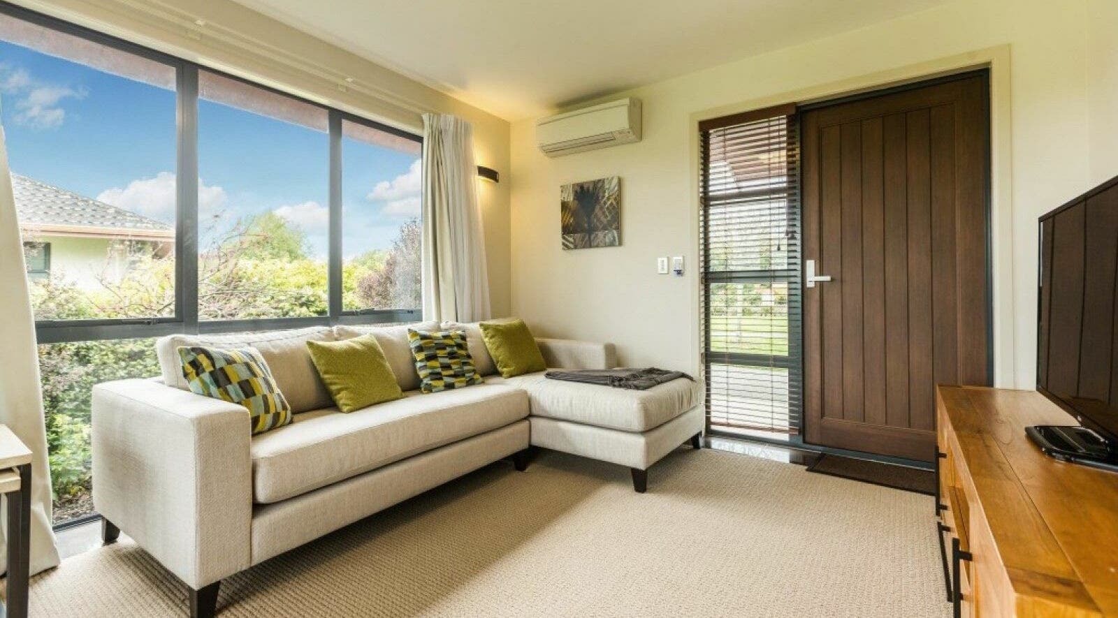 Bright lounge at Resolution Retreats Health and Wellness Centre, Cambridge, Waikato, NZ, with large windows.
